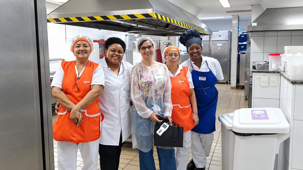 Ana Beatriz Móras em avaliação ergonômica em cozinha industrial, com a equipe do local